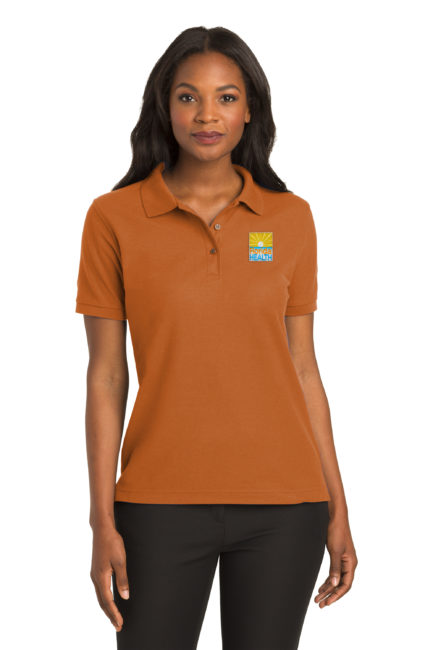 Female Model Wearing L500 Polo in Texas Orange